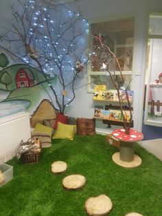 an indoor play area with fake grass and trees