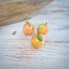 three pieces of fruit sitting on top of a wooden table