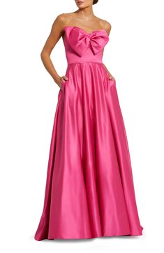 A swishy skirt and a bow-bopped bodice animate a lustrous gown designed to show off your shoulders and perfected with a pair of pockets. 61" length Hidden back-zip closure Strapless Side-seam pockets Lined 100% polyester Spot clean Imported Asian Owned/Founded Prom Ballgown, Robe Fuchsia, Champagne Formal Dresses, Navy Blue Bridesmaid Dresses, Blue Sequin Dress, Formal Dresses With Sleeves, Fuchsia Dress, Maternity Dresses For Photoshoot, Red Wedding Dresses