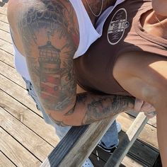 a man with tattoos on his arm sitting next to a woman