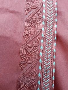 closeup of pink fabric with white thread on the bottom and blue trim around it