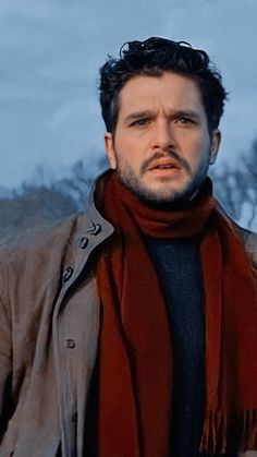 a man wearing a brown jacket and red scarf