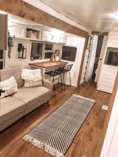 a living room filled with furniture next to a kitchen