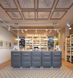 the inside of a store with many shelves and lights above it, along with pictures on the wall