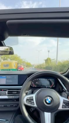 the driver's view of a bmw car driving on a road with other cars in the background