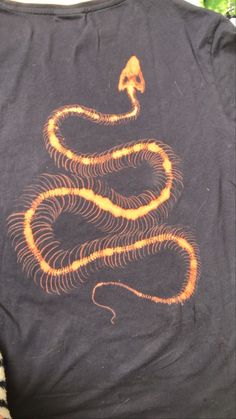 a black shirt with an orange snake on it