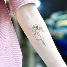 a woman's arm with a flower tattoo on the left side of her arm