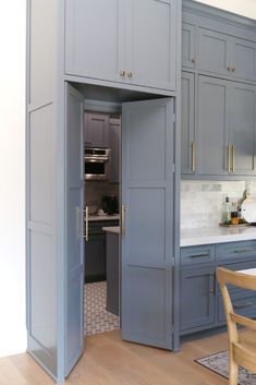 an open door leading to a kitchen with blue cabinets