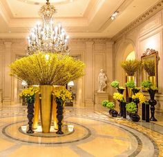 there are many vases with flowers in them on the floor and chandelier