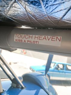 a sticker that says touch heaven kiss a pilot on the side of a blue car