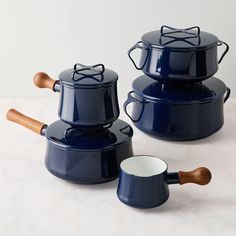 three blue pots with wooden spoons and lids