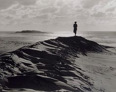 a person standing on top of a sand dune