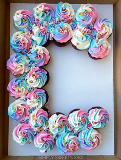 a box filled with cupcakes and frosting in the shape of the letter e