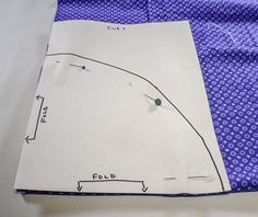 a piece of paper with a ruler on it next to a blue polka dot fabric