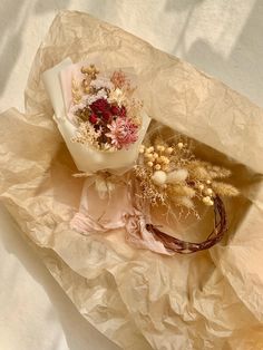 two dried flowers sitting on top of a piece of crumpled paper next to each other