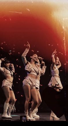 the dancers are performing on stage in front of an orange and red background with bubbles