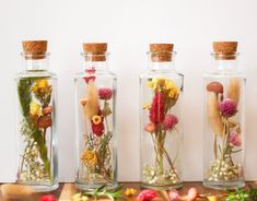 three glass bottles filled with different types of flowers