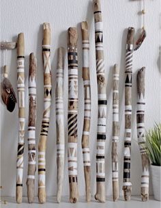 a group of wooden sticks sitting on top of a white table next to a potted plant