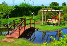 a wooden bridge over a small pond