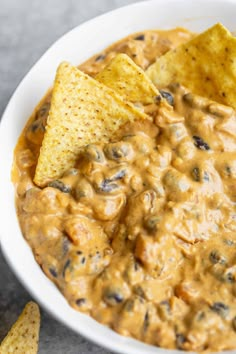 a white bowl filled with tortilla chips and salsa