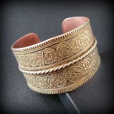 Vintage wide brass bracelet, chunky bracelet, Wide open wrist bangle bracelet, Handmade Copper & Brass Bracelet Ethnic Geometric Design Metal -  bronze outside, copper inside Stone -   Size - 6 3/4'' , wide '' Mark -  Circa  before the 2000s  Condition - good condition.  PLEASE NOTE: Vintage jewelry can show signs of wear and discoloration or chipped metal consistent with age. Please look at the pictures carefully. Most were purchased at estate sales, auctions, etc. so they could need cleaning. Bohemian Antique Gold Bracelets For Gift, Brass Bracelets With Intricate Design For Festivals, Bohemian Antique Gold Brass Bracelets, Bohemian Metal Cuff Bracelet With Intricate Design, Bronze Cuff Bracelet With Intricate Design For Gift, Bronze Brass Bracelets With Intricate Design, Handmade Antique Gold Bohemian Bracelets, Adjustable Intricate Design Cuff Bracelet For Festivals, Adjustable Intricate Cuff Bracelet For Festivals