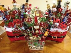 a christmas basket filled with liquor bottles on top of a wooden table