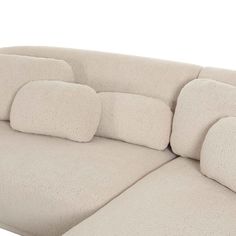 a large beige couch with pillows on it's back and arm rests in front of a white background