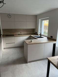 an empty kitchen with white cabinets and counter tops