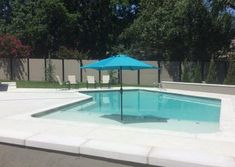 an empty swimming pool with a blue umbrella