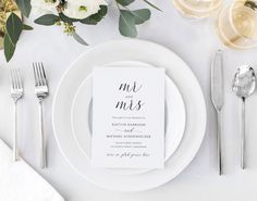 a white plate topped with a menu next to silver utensils and napkins