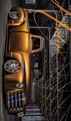 an old car is parked on the side of a building in front of some scaffolding