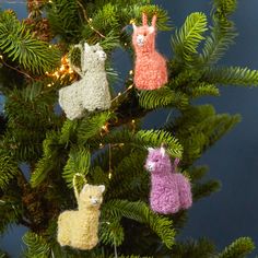 three knit llama ornaments hanging from a christmas tree