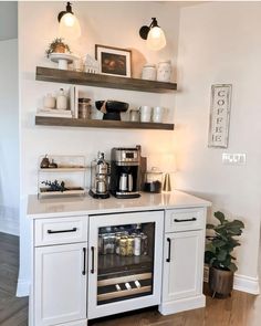 there is a coffee maker on the counter in this kitchen with white cabinets and open shelving