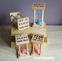 three miniature wooden sand timers with words written on them sitting on top of each other