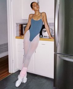 a woman in tights is standing on the kitchen counter