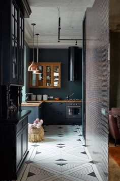 a kitchen with black cabinets and white flooring