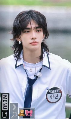 a young man wearing a white shirt and blue tie with badges on his collar is looking at the camera