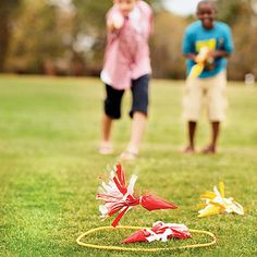 two people are playing frisbee golf in the grass with one person standing behind it