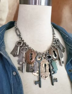 Repurposed Skeleton Key and Door Escutcheon Industrial Style Statement Necklace - Upcycled Door Hardware Necklace from Key of A Upcycled Jewelry There's something about vintage and antique hardware that is aesthetically pleasing to the eye.  The shapes, metal tones and not to mention the history that comes with each component.  What door did they open?  What doors were they part of and what stories they all could tell! This necklace features a random mix of beautifully aged door escutcheons.  They are mostly steel but each has a unique shape, patina and size.  One is painted a satiny black and there are two lovely matching bronze oval ones.  The cadillac of the bunch that I placed front and center is a vintage Eastlake style cast escutcheon that is simply stunning   The skeleton keys consi Key Earrings, Things To Make With Old Jewelry, Old Key Crafts, Antique Key Necklace, Skeleton Key Jewelry, Key Necklace Vintage, Vintage Skeleton Keys, Upcycled Vintage Jewelry, Skeleton Key Necklace