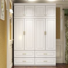 an empty room with white cabinets and wood floors