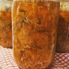 three jars filled with food sitting on top of a red and white checkered table cloth