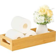 two rolls of toilet paper in a wooden holder with flowers on the side and one roll of tissue next to it