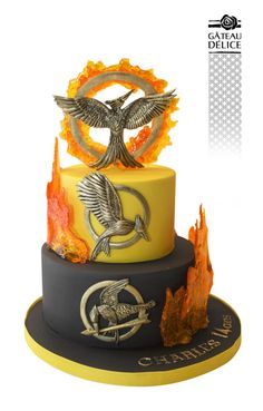 a three tiered cake decorated with an image of a bird and fire on top