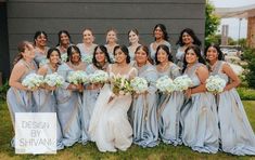 a group of women standing next to each other in front of a building holding bouquets