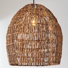 a light that is made out of wicker hanging from a ceiling fixture in a room