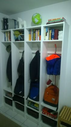 a white bookcase filled with books and backpacks