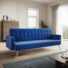 a blue couch sitting on top of a hard wood floor next to a wooden table