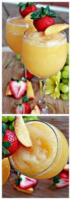 two glasses filled with fruit and garnish on top of a wooden table next to some strawberries