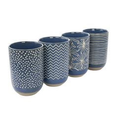 four blue cups with white designs on them