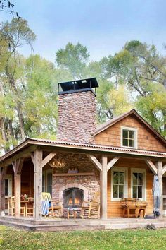 a painting of a log cabin with an outdoor fireplace and covered patio area in the foreground